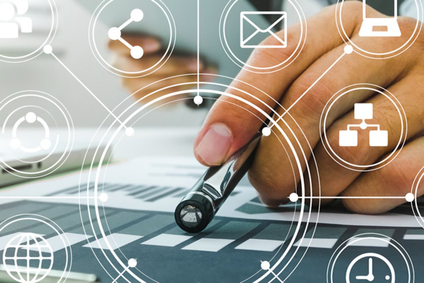 Nahaufnahme einer Hand, die mit einem Stift auf ein Diagramm zeigt. Im Vordergrund sind transparente weiße Icons wie Briefumschlagen, Vernetzungssymbol u. a. aus dem IT-Bereich zu sehen 