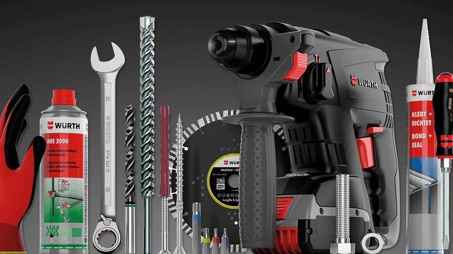 Produktpräsentation von WÜRTH-Werkzeugen und -Zubehör vor dunklem Hintergrund. Zentral abgebildet ist ein Bohrhammer. Drumherum stehen verschiedene Werkzeuge und Materialien: ein Maulschlüssel, Bohrer, Bits, eine Trennscheibe, Dichtmittel, Handschuhe, ein Spray, eine Kartusche mit Kleb- und Dichtstoff sowie Schrauben und Dübel. Alle Produkte tragen das WÜRTH-Logo